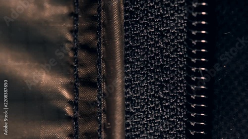Close up view of a tent zipper moving in the wind at night