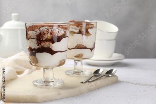 Fotografie Tasty tiramisu in dessert coupes served on white table, closeup