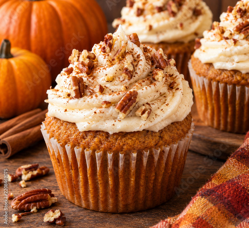 Several pumpkin cupcakes on a table during autumn