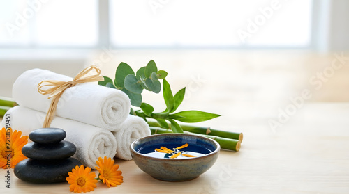 a towel, a bowl of soap, and some flowers on a table
