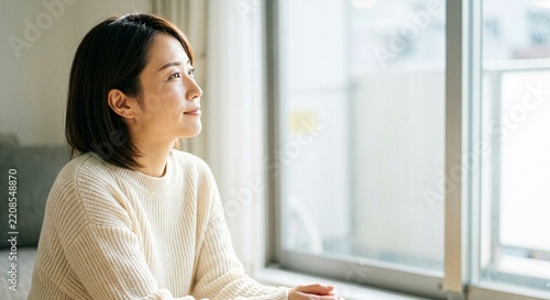 冬の朝に窓辺にいる日本人女性
