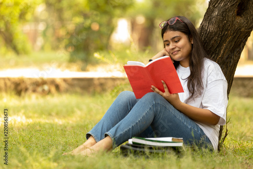 Indian college student young girl studying at park