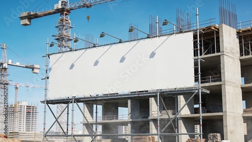 Large Blank White Construction Billboard Mockup at Modern Building Site with Tower Cranes and Scaffolding Under Daylight