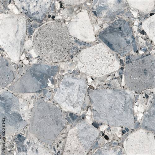Close view of irregular gray stone paving with pale mortar joints, showing natural speckles, rough texture, and varied rock shapes.