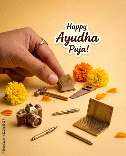 Ayudha Puja Festival Concept with Hand Placing Miniature Book Among Laptop, Camera, Tools
