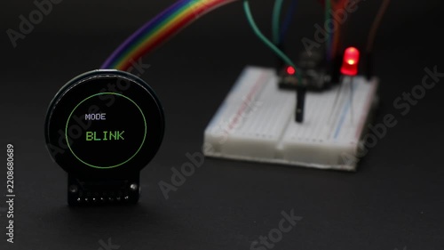 Round lcd display connected to breadboard with jumper cables showing led light patterns