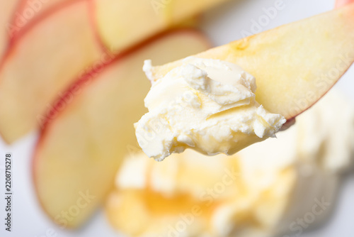 Close-up of sliced red apple with cream cheese and honey to eat, Top view