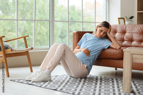 Pregnancy stress and mental health, tired pregnant woman sitting on floor at ...