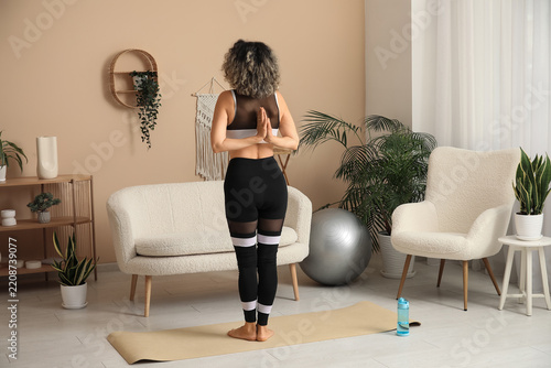 Mindfulness and wellness, woman practicing yoga at home with prayer hands for...