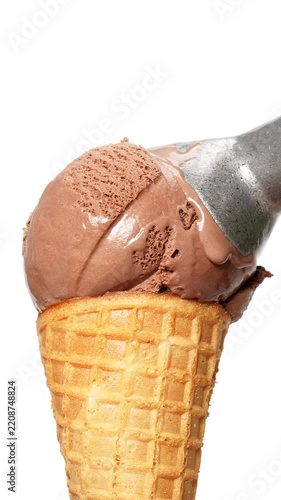 4K Metal ice cream scoop placing a rich chocolate ice cream ball onto a crispy waffle cone isolated on white background.