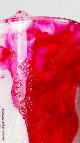 4K footage sweet red syrup pouring into crushed shaved ice in a clear glass vivid color swirl and dynamic fluid pattern for Thai shaved ice dessert concept.
