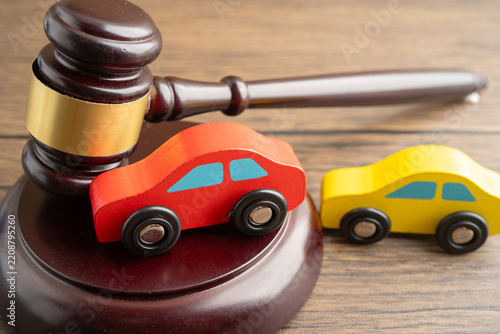 Car accident lawsuit and insurance, Judge hammer with car model.