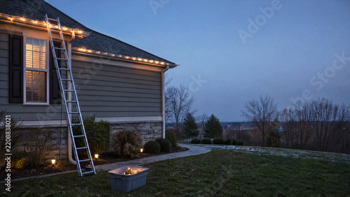 Ladder and string lights on a house gutter
