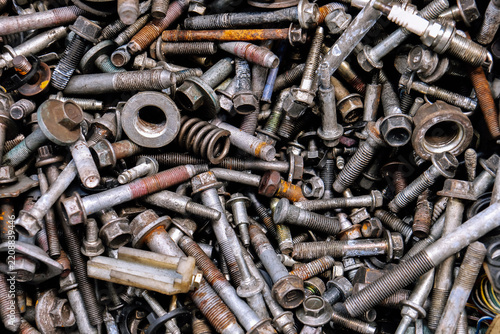 Rusty metal bolts and screws creating industrial background