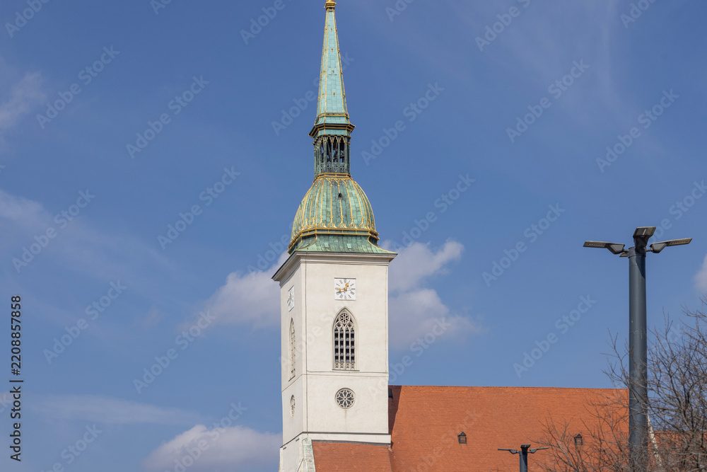 Obraz premium St Martin's Cathedral church with gothic spire and green copper roof under blue sky, Bratislava, Slovakia