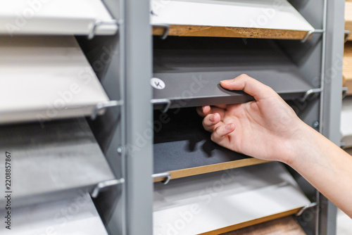 Hand Selecting a Furniture Material Sample on Display Shelving
