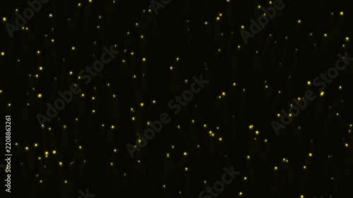 Golden glowing particles floating on a dark black background