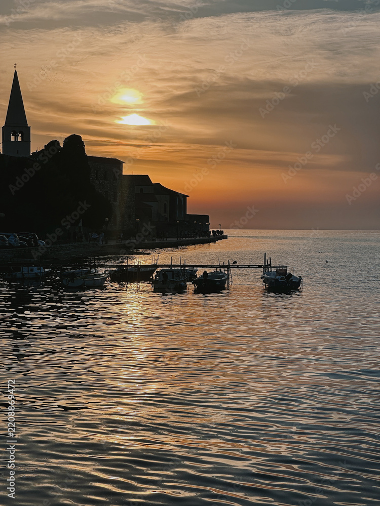 Fototapeta premium Sunset Over Coastal Town with Reflections