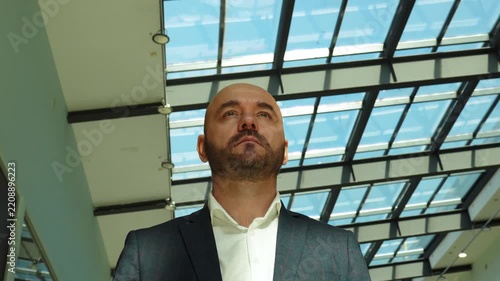 Confident businessman standing under a glass ceiling