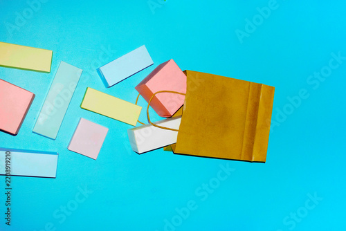 Colorful geometric blocks spilling from a shopping bag on blue