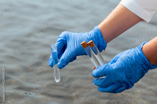 scientist gloved hands collecting water sample test tubes lake river surface microplastic pollution testing environmental research concept of ecology contamination science