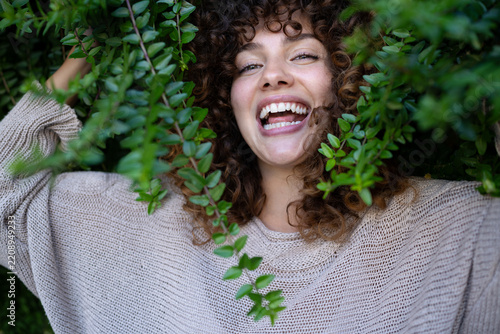 White woman with curly hair smiles warmly