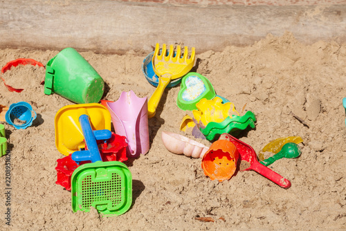 Buntes Spielzeug in einem Sankasten eines Kinderspielplatzes, Deutschland