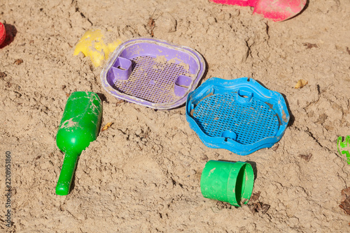 Buntes Spielzeug in einem Sankasten eines Kinderspielplatzes, Deutschland