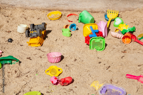 Buntes Spielzeug in einem Sankasten eines Kinderspielplatzes, Deutschland