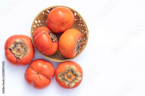 Top View of Persimmon Fruit in Bamboo Basket Isolated on White Background with Copy Space