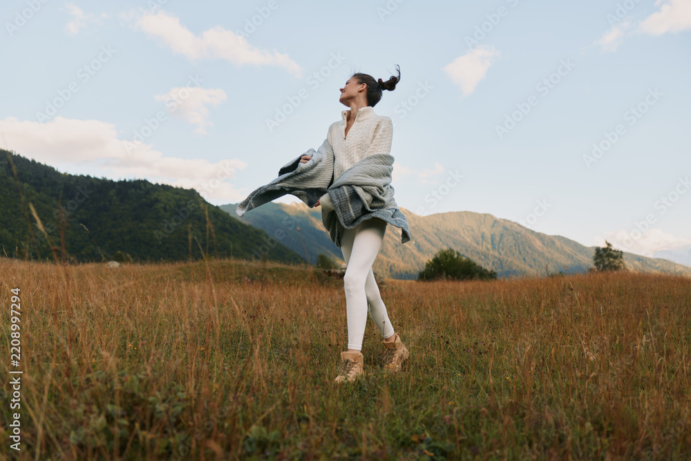 Obraz premium Cheerful woman outdoors in a sunlit field, carefree posture, natural colors, light breeze, relaxed lifestyle moment, joyful smile toward the horizon