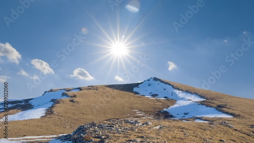 snowbound mountain ridge under a sparkle sun time lapse scene