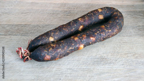 Professionally aged cured salami links ready for serving, arranged on a vintage wooden tabletop.
