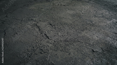 Dark grunge texture of rough concrete surface with small cracks and grain close up