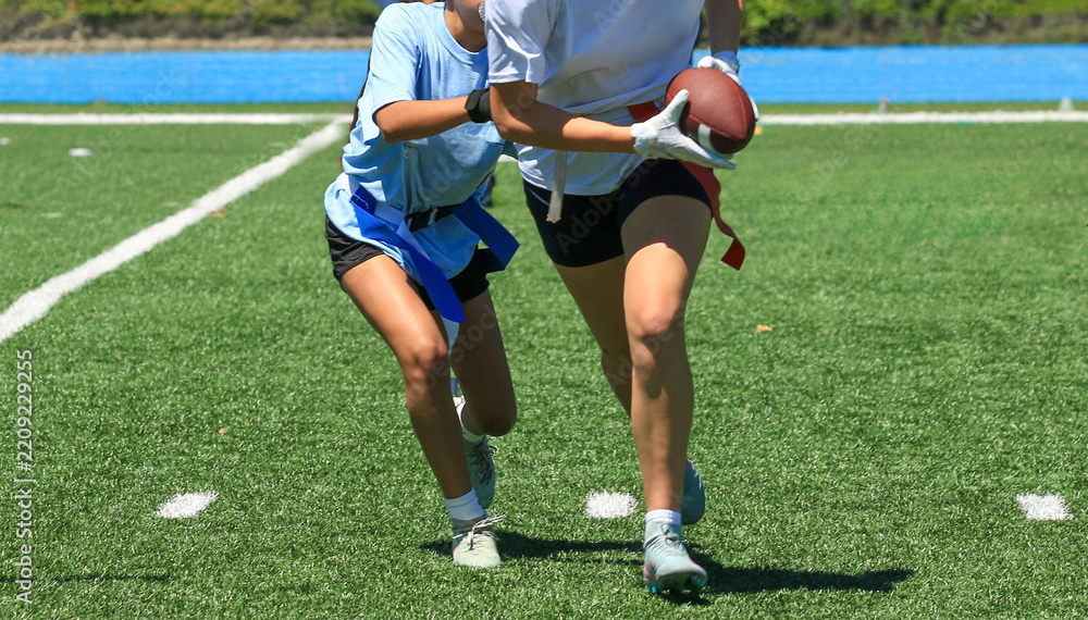 Obraz premium Defender Pulling the Flag of Opponent During a Girls Flag Football Game