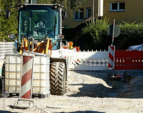 Parked caterpillar in a road construction site behind construction material