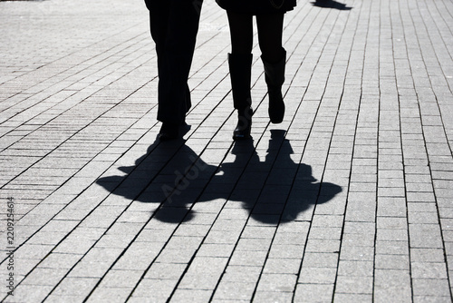 Silhouettes and shadows of two women walking down the street. Concept of female friendship
