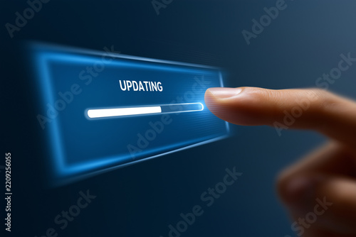 Finger touching virtual updating progress bar on blue holographic screen, technology software upgrade concept.