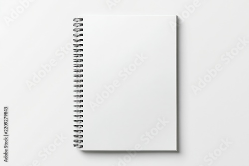 Inspecting the pristine white notebook, its spiral binding stands out against the blank pages.