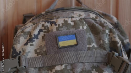 Tactical military backpack with Ukrainian flag patch hanging in bunker