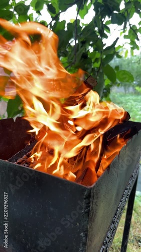 Close-up of flames scattering in the wind from a barbecue grill outdoors. High quality 4k footage