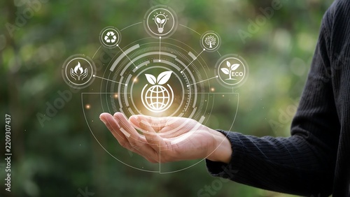 Hand holding glowing global sustainability network with eco icons in soft focus nature background