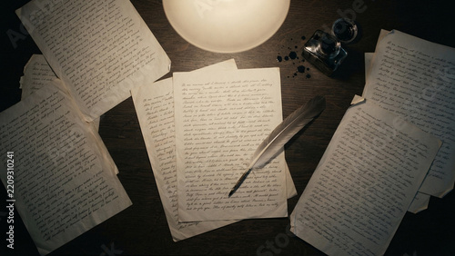Vintage writing desk with manuscripts quill pen and inkwell