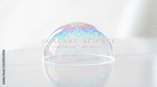 Iridescent soap-bubble dome resting on a clean white surface, minimalist macro photography, translucent cyan, pink and violet spectral highlights, high-key light, delicate glossy edge, skincare