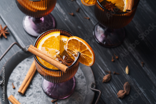 White mulled wine with citrus and spices in glasses for autumn and Christmas drinks