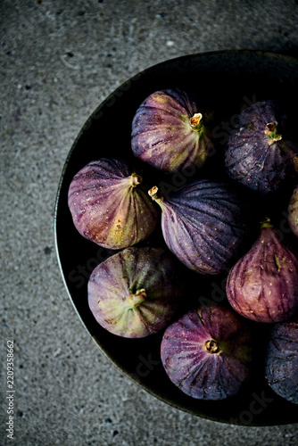 Fresh organic purple figs on a black ceramic plate