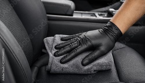 Professional automotive interior detailing service with microfiber towel and protective gloves