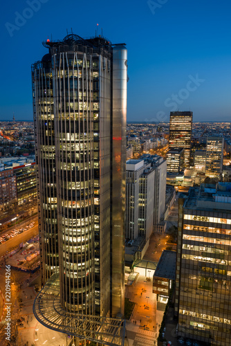 Aerial view of the iconic Torres KIO skyscrapers illuminated at twilight, featuring their inclined architecture, overlooking the city skyline of Madrid, Community of Madrid, Spain.