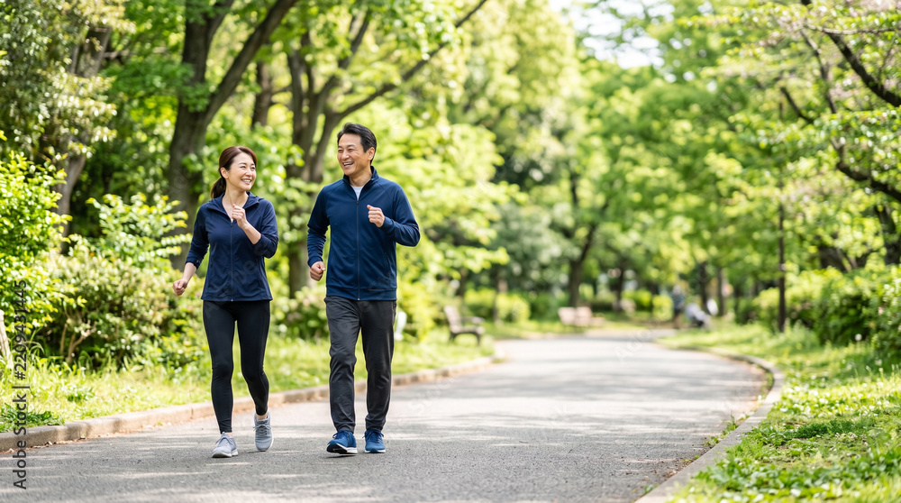 Obraz premium Happy asian couple power walking in park healthy lifestyle training fitness activity enjoying nature outdoors exercise together joy