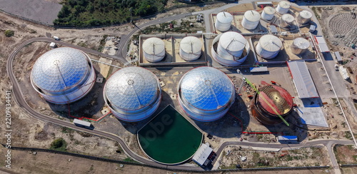 Aerial view of industrial fuel tanks and storage facility with large spherical structures and a green reservoir in Kovin, Vojvodina, Serbia.